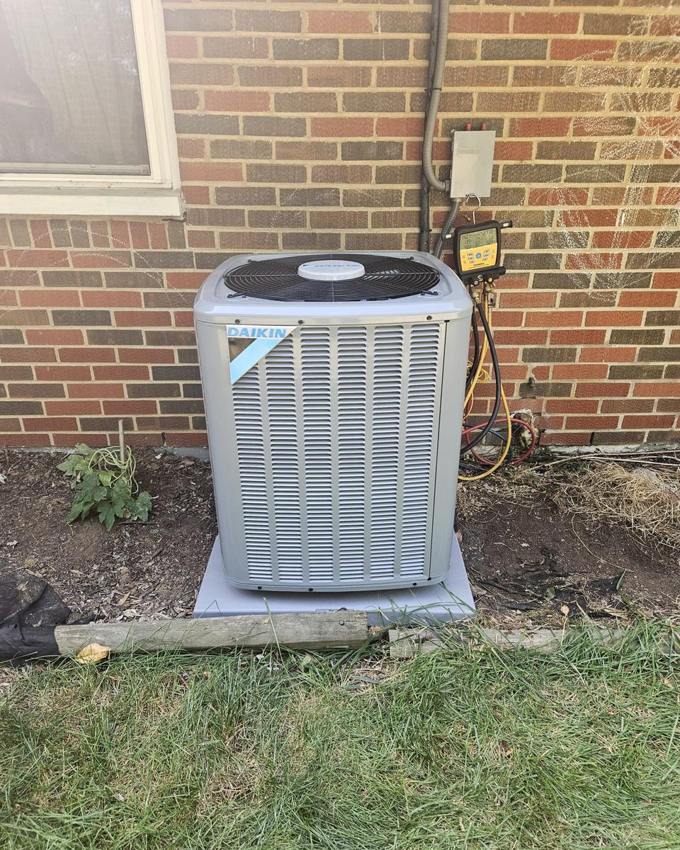 Daikin outdoor unit installed beside a brick house